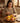 Woman cutting a mango on a wooden table with a warm interior setting
