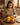 Woman cutting a mango on a wooden table with a warm interior setting